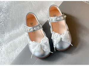 Elegant silver Mary Jane shoes for girls with lace bow and pearl strap details.