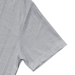 Detailopname van de getextureerde linnen-look stof van een grijs herenshirt met korte mouwen.