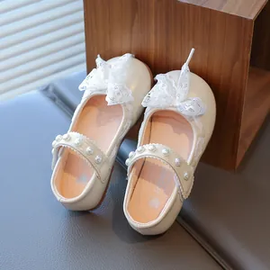 Elegant cream Mary Jane shoes for girls with lace bow and pearl strap detail.