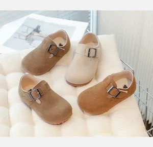 High-angle view of kids suede Mary Jane shoes in four earth-tone colors on a white mat