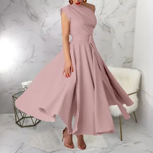 Detail view of the flared hem and belted waist on a pink sleeveless one-shoulder maxi dress