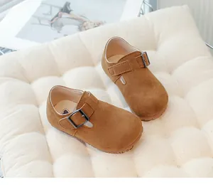 High-quality close-up of brown suede children's Birkenstock-style shoes with buckle strap