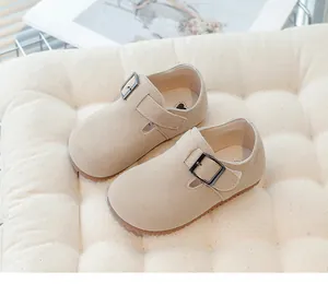 Macro view of vintage beige suede children's shoes featuring an adjustable buckle strap