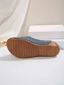 Vue détaillée de la semelle marron antidérapante d'une pantoufle à plateforme bleue
