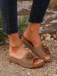 Vue détaillée de sandales compensées marron avec décor floral élégant et bout ouvert
