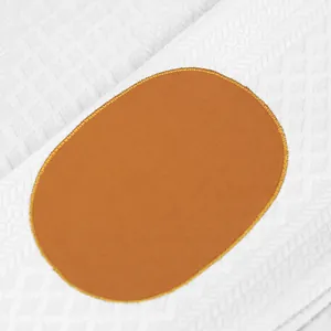 Vue macro détaillée du tissu en maille jacquard blanc avec écusson orange ovale cousu