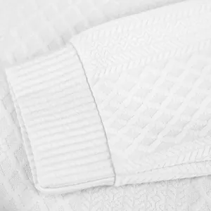 Vue détaillée du tricot texturé jacquard blanc et du poignet côtelé pour hommes