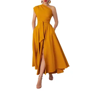 Close-up of mustard yellow one-shoulder maxi dress with belted waist and slit.