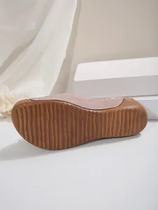 Détail d'une pantoufle à semelle épaisse montrant la semelle en caoutchouc marron et la taille 37
