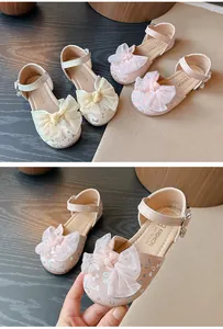 Detailed view of pink girl's sandals with elegant bowknot and silver heart prints