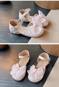 Close-up of pink girls' sandals with large lace bows and glitter details.
