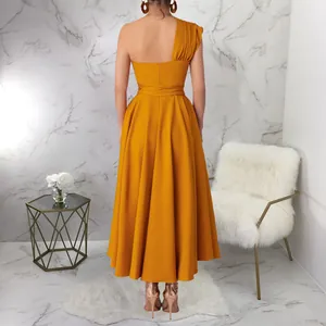 Elegant ginger yellow one-shoulder sleeveless maxi dress with a cinched waist and full skirt