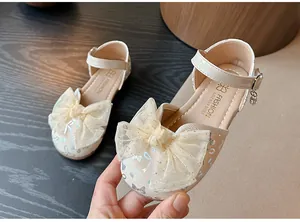 Detailed view of girls' cream princess sandals with decorative mesh bow and pearl charm