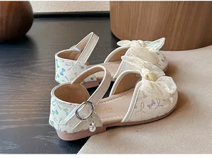Close-up of white girl's princess shoes with mesh bow and butterfly patterns