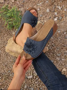 Vue détaillée de sandales compensées bleues avec fleur et bout ouvert