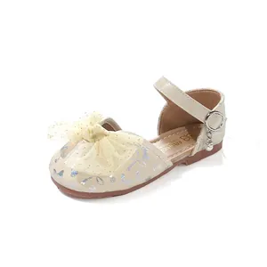 Detailed view of girl's champagne princess sandal with sparkly bow patterns and tulle