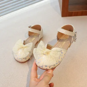 Elegant beige girls closed-toe sandals featuring a large lace bow and shiny butterfly prints