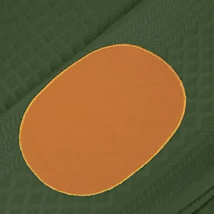 Vue macro détaillée d'un coude orange sur un tissu en maille jacquard vert texturé