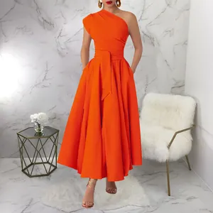 Elegant orange one-shoulder sleeveless belted maxi dress on model in stylish room