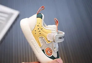 Detailed close-up of soft-sole baby sneaker with donut patch and velcro strap
