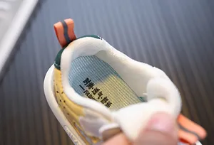 Macro view of breathable mesh insole inside yellow and orange toddler sneakers for babies