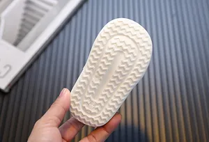 Detailed macro view of the anti-slip wavy texture on a white toddler walking shoe sole