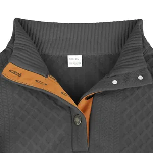 Gros plan d'un sweat-shirt à texture jacquard avec col montant et patte de boutonnage.