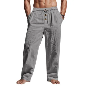 Dettaglio di pantaloni casual in lino grigio con coulisse e bottoni.