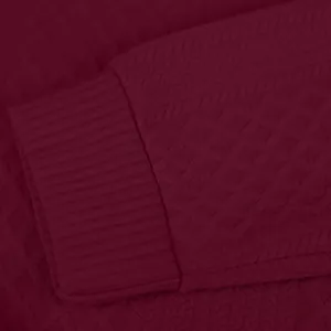 Vue macro du tissu en maille jacquard bordeaux et du détail des poignets côtelés pour homme.
