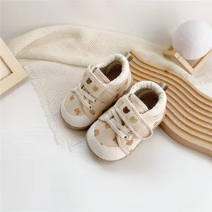 Close-up of baby walking shoes with cute cartoon bear pattern and velcro straps