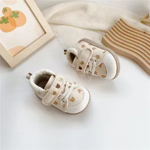 Detail view of baby soft-sole walking shoes with bear pattern and Velcro strap.