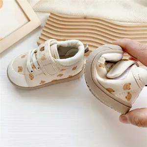 Close-up of flexible soft sole baby walking shoes with cute cartoon bear pattern and strap