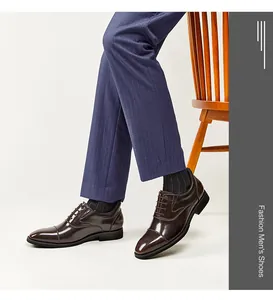 Side view of dark brown polished leather oxford shoes worn with navy pinstripe trousers