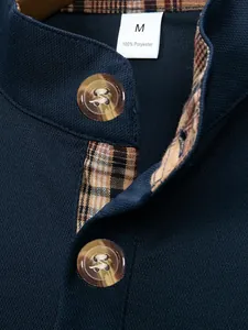 Close-up detail of navy blue men's polo shirt featuring stand collar and plaid inner trim