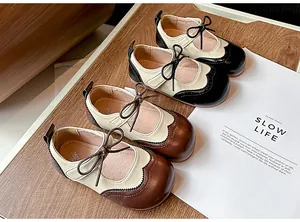 Gros plan de chaussures Mary Jane bicolores pour enfants de styles noir et marron