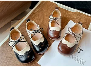 Vue détaillée de chaussures pour filles style richelieu britannique en noir et marron.