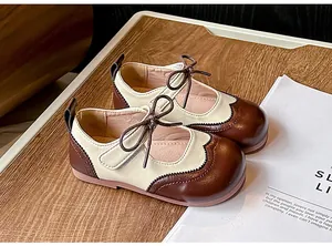 Détail de chaussures Mary Jane brogue de style britannique pour filles en marron.