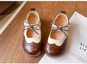 Détail de chaussures Mary Janes de style brogue pour filles en marron et beige