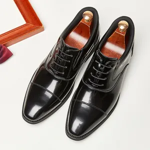 Polished black men's cap-toe Oxford shoes in a classic English business formal style