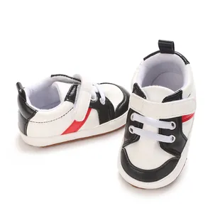 Détail rapproché de chaussures de marche pour bébé à semelle souple, blanc et rouge.