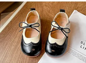 Vue détaillée de chaussures Mary Jane bicolores pour enfants avec détails richelieu.