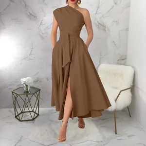 Detail of a brown one-shoulder sleeveless dress with high-waisted belt and pleated slit skirt