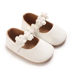 Détail de chaussures princesse blanches pour bébé fille avec fleurs 3D et perles