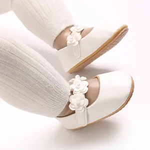 Gros plan de chaussures de princesse pour bébé en PU blanc avec décorations florales