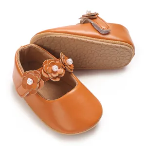 Gros plan de chaussures de princesse pour bébé fille en simili cuir marron avec fleurs