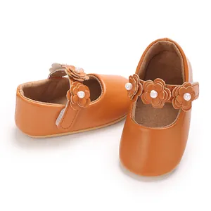 Vue détaillée de chaussures Mary Jane brunes pour bébé avec fleurs sur la bride