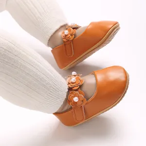 Gros plan de douces chaussures de princesse en PU orange avec détails de fleurs