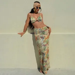 Close-up of sexy two-piece beach set with pearl chain detail and tropical leaf print