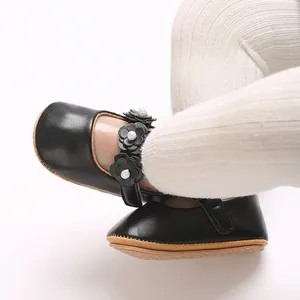 Gros plan sur des chaussures de princesse en PU noir pour bébé avec fleurs et perles