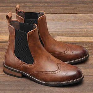 Κοντινό πλάνο καφέ μποτάκια Chelsea με brogue σχέδια και δερμάτινη υφή υψηλής ποιότητας